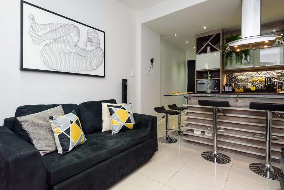 Large and well-lit living room, equipped with sofa, TV and air conditioning