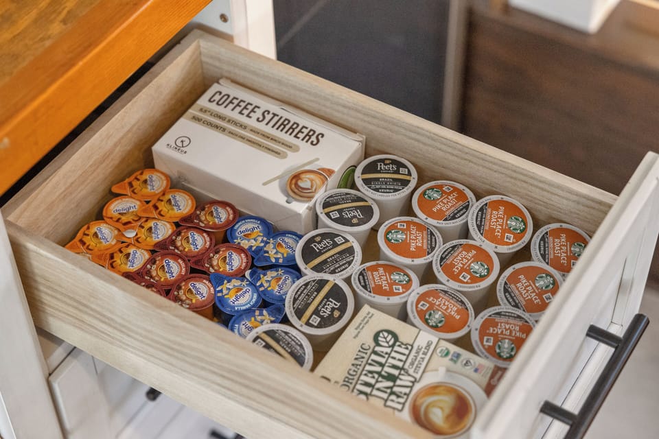 Loft kitchenette: coffee supplies drawer with pods, creamers, and stirrers.