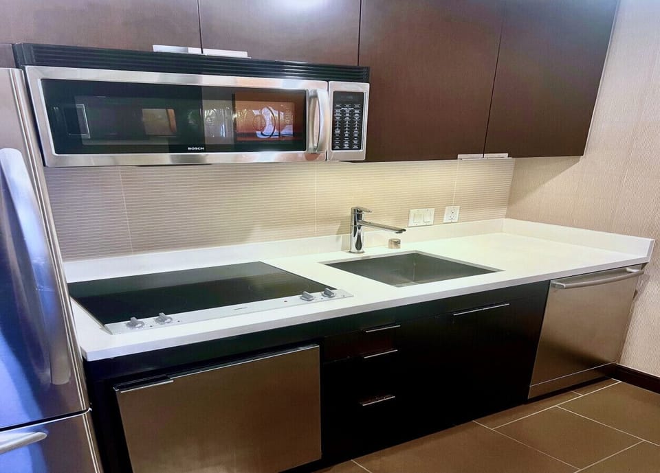 The kitchen featuring a stove, refrigerator, microwave, laundry machine, dryer and a dining area.
