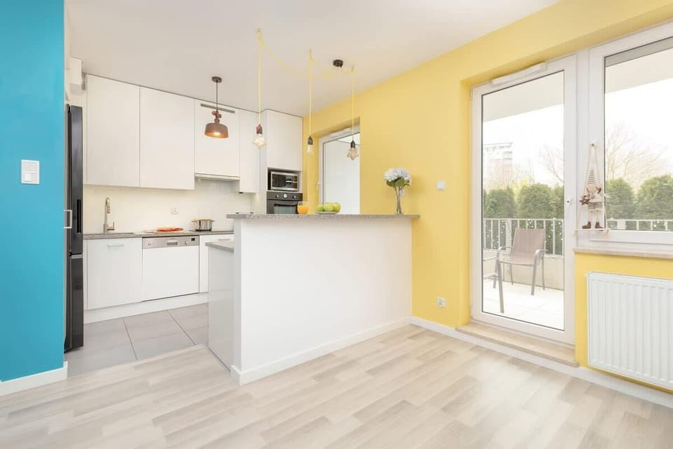 A unique kitchen with white cabinets, stainless steel appliances and minimalist décor.