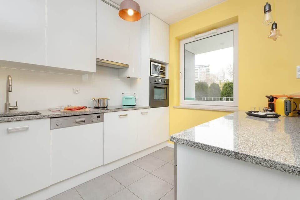 Clean, modern kitchen with white cabinets, stainless steel appliances, and minimalist decor.
