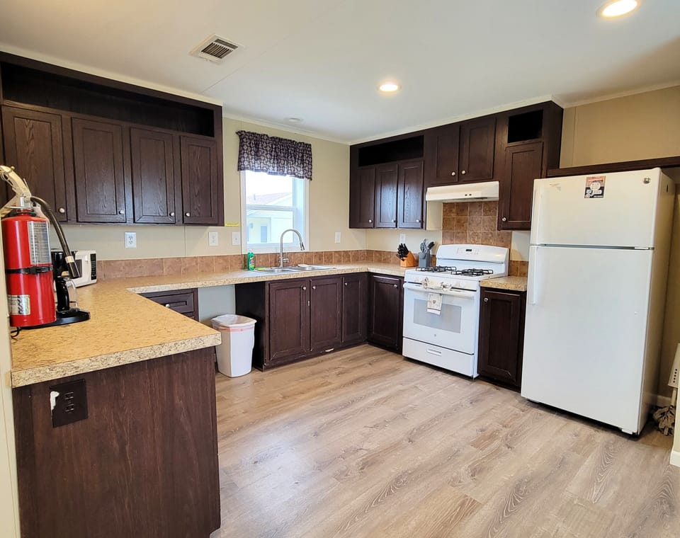 There is a full kitchen with a refrigerator, gas stove, and microwave.