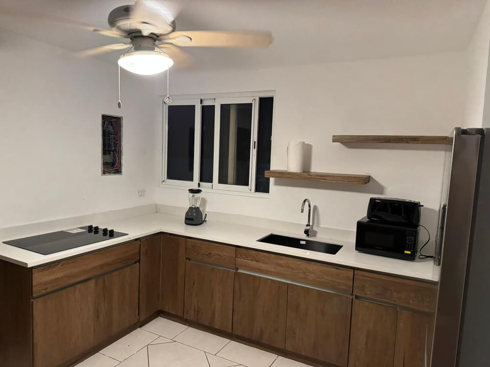 Kitchen with full refrigerator and stove for cooking 