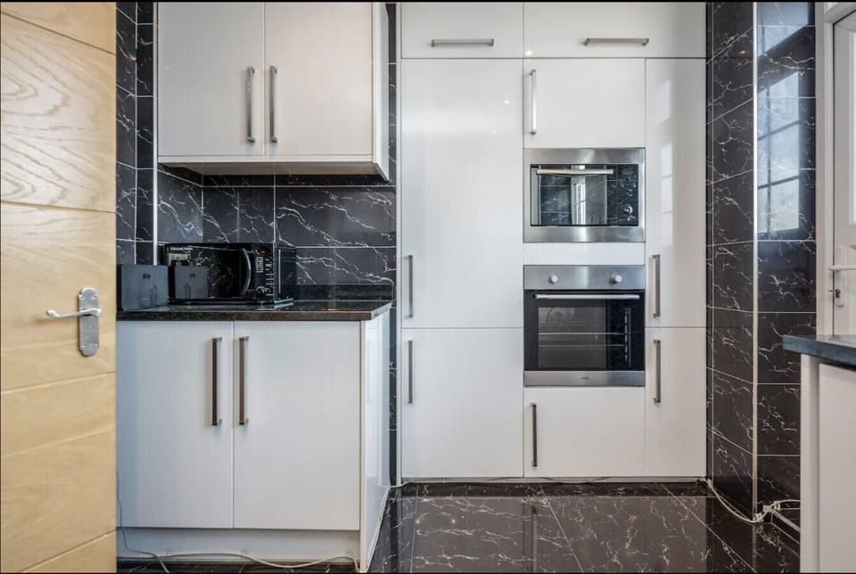 Kitchen — modern kitchen area with an integrated oven, microwave and extensive cabinet storage. Practical layout designed for longer stays and convenient home cooking in Central London.