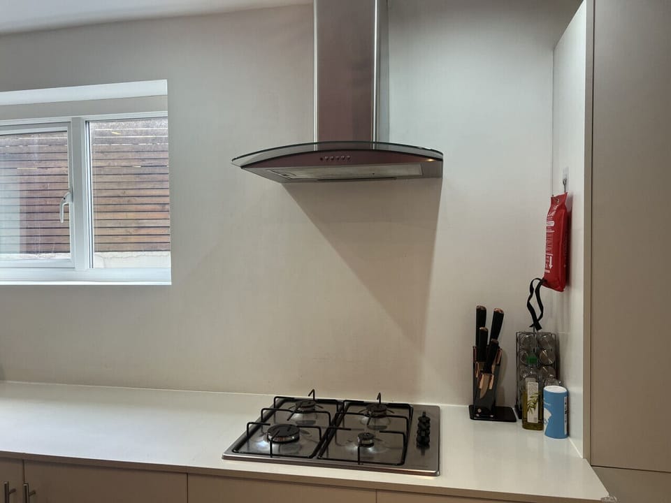 Ground Floor, Kitchen - Vibrant Haven: A sleek cooking area with a gas hob, stainless steel extractor fan, and a minimalist backsplash for a clean and modern aesthetic.