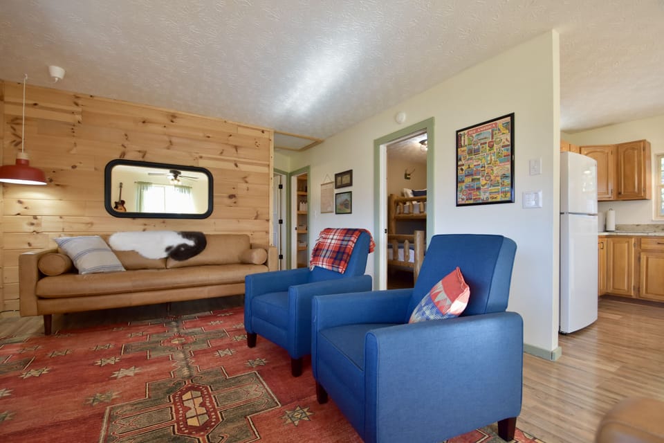 Living room is open to kitchen/dining to right, bedrooms/bathrooms down the hall