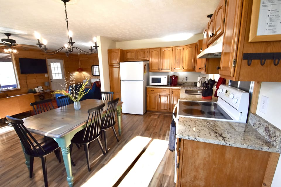 Morning light streams into open, full kitchen well equipped for cooking/baking.