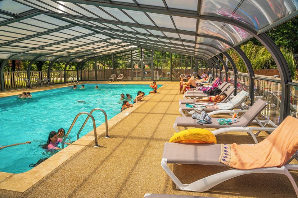 Relaxing poolside loungers under a covered area, offering comfort and shade.