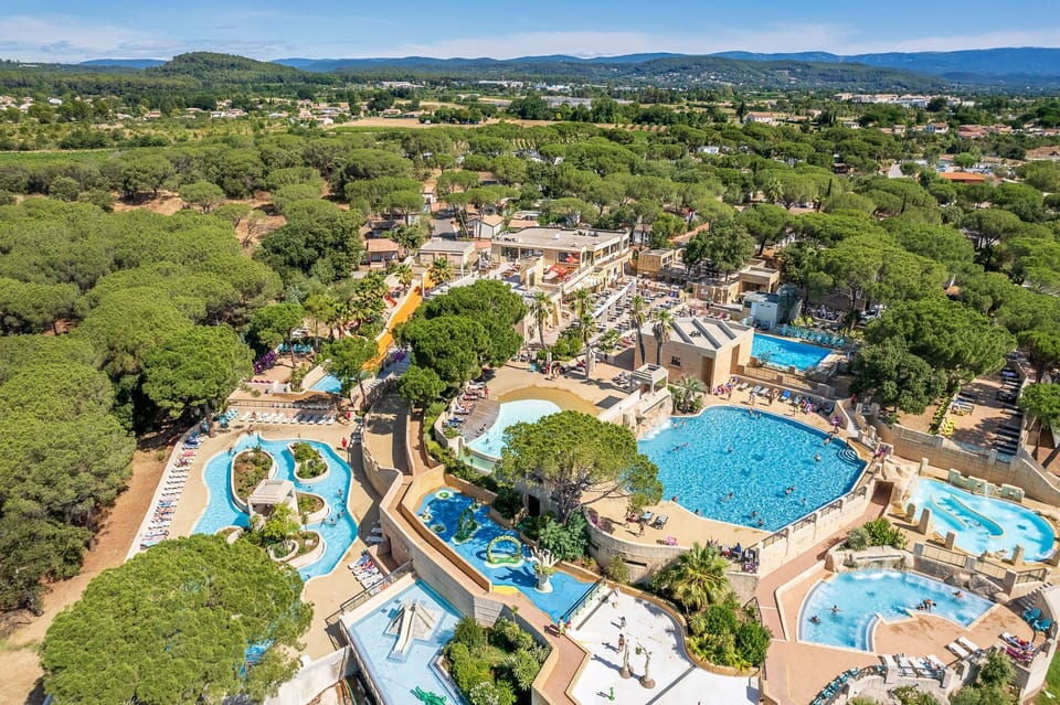 Dive into a vibrant water park, complete with multiple pools and thrilling slides surrounded by lush greenery.