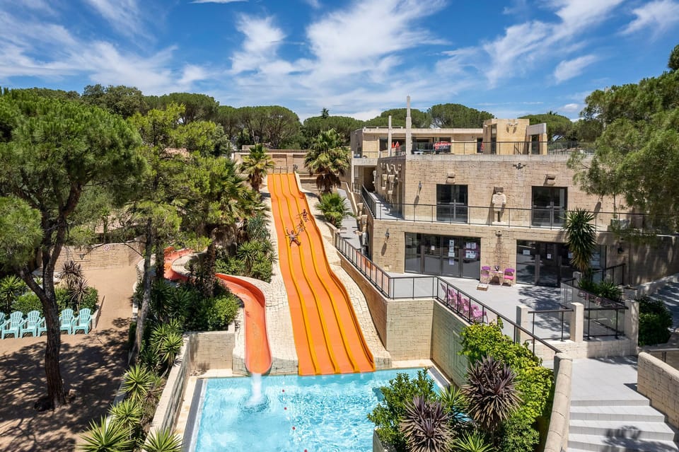 Experience the rush down the vibrant orange water slide, perfect for a day of fun in the sun.
