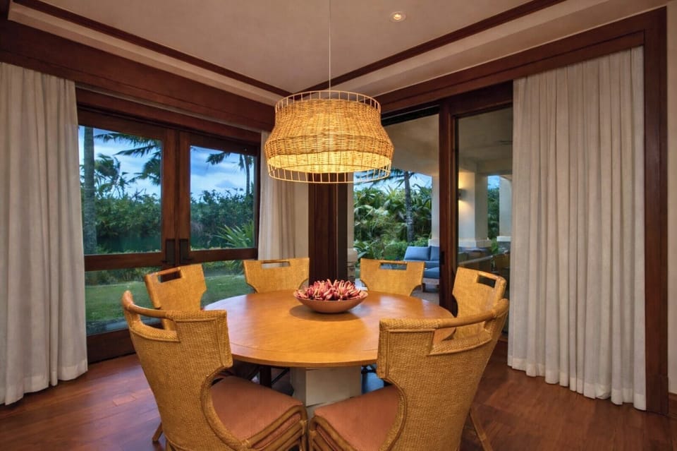 A round wood dining table sits beneath a statement chandelier, creating an inviting space for shared meals and conversation.