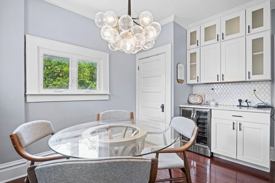 Morning fuel station! Gather the family around the bright dining table, complete with a modern bubble chandelier and a dedicated wine and beverage fridge.