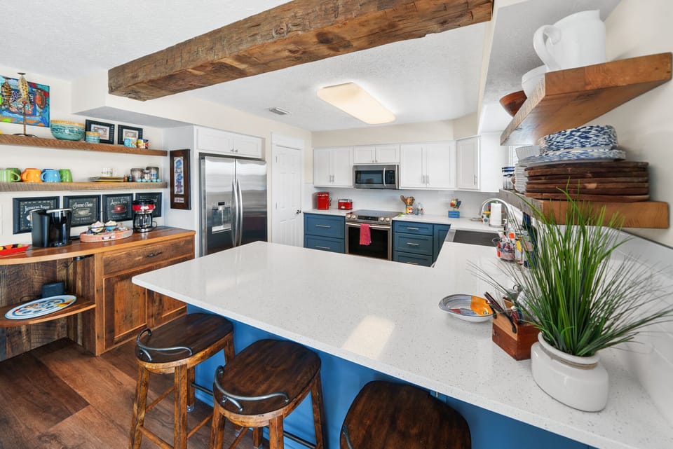 Cook memorable meals in your fully equipped kitchen featuring rustic wood beams, modern appliances, and a spacious island perfect for gathering.