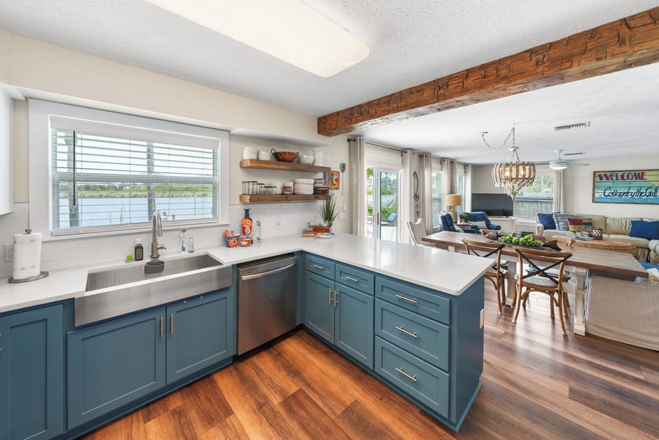 Your bright, modern kitchen features beautiful blue cabinets and flows seamlessly into the cozy living space—perfect for cooking and gathering together.