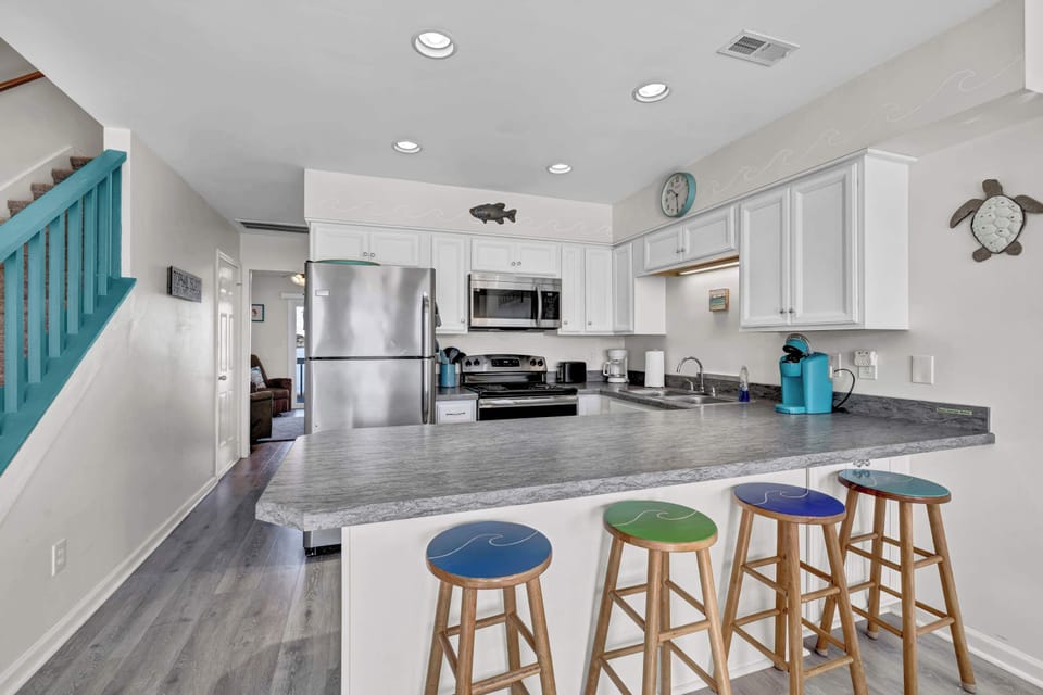 This bright and spacious eat-in kitchen features modern appliances and a large island with seating. Perfect for preparing meals and gathering with family or friends.