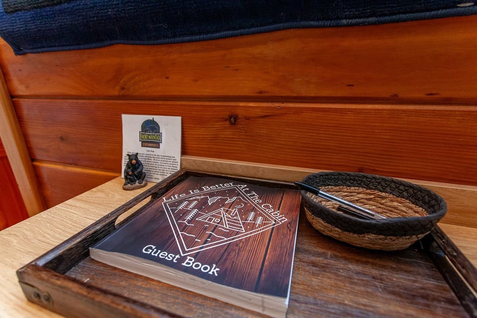 Decorative tabletop arrangement with a woven basket, framed artwork, and wood-paneled backdrop inside Dream Circle Cabin. Rustic cabin details complement the mountain setting in Bryson City.