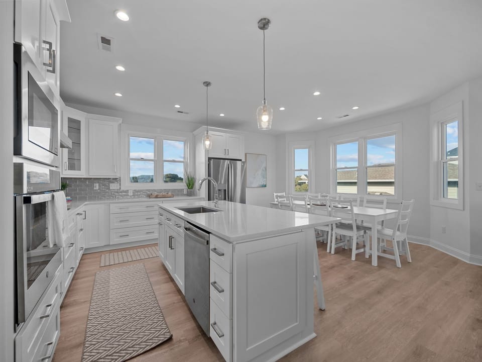 Large fully stocked kitchen with eat in island and 10 person dining table