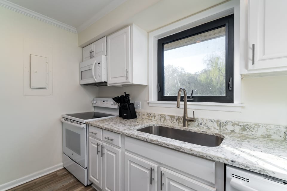 The kitchen has custom cabinets, granite counters, and new appliances