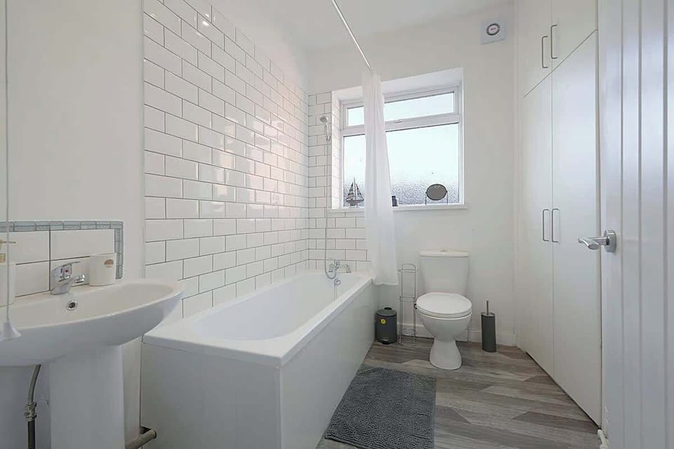 The bathroom benefits from a bath with an overhead shower combination, toilet and a sink. 