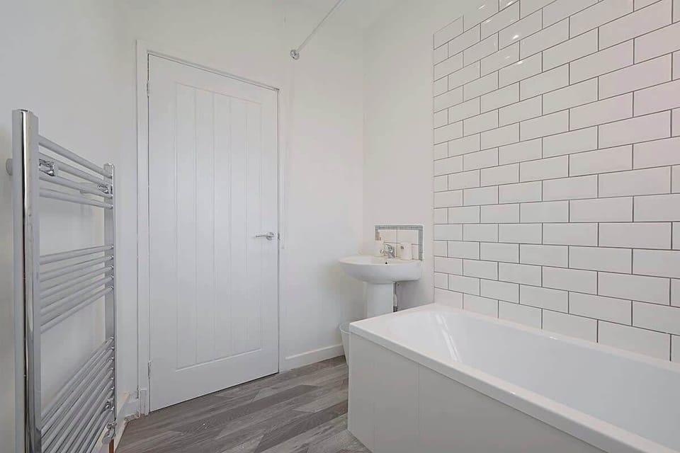 The bathroom benefits from a bath with an overhead shower combination, toilet and a sink. 