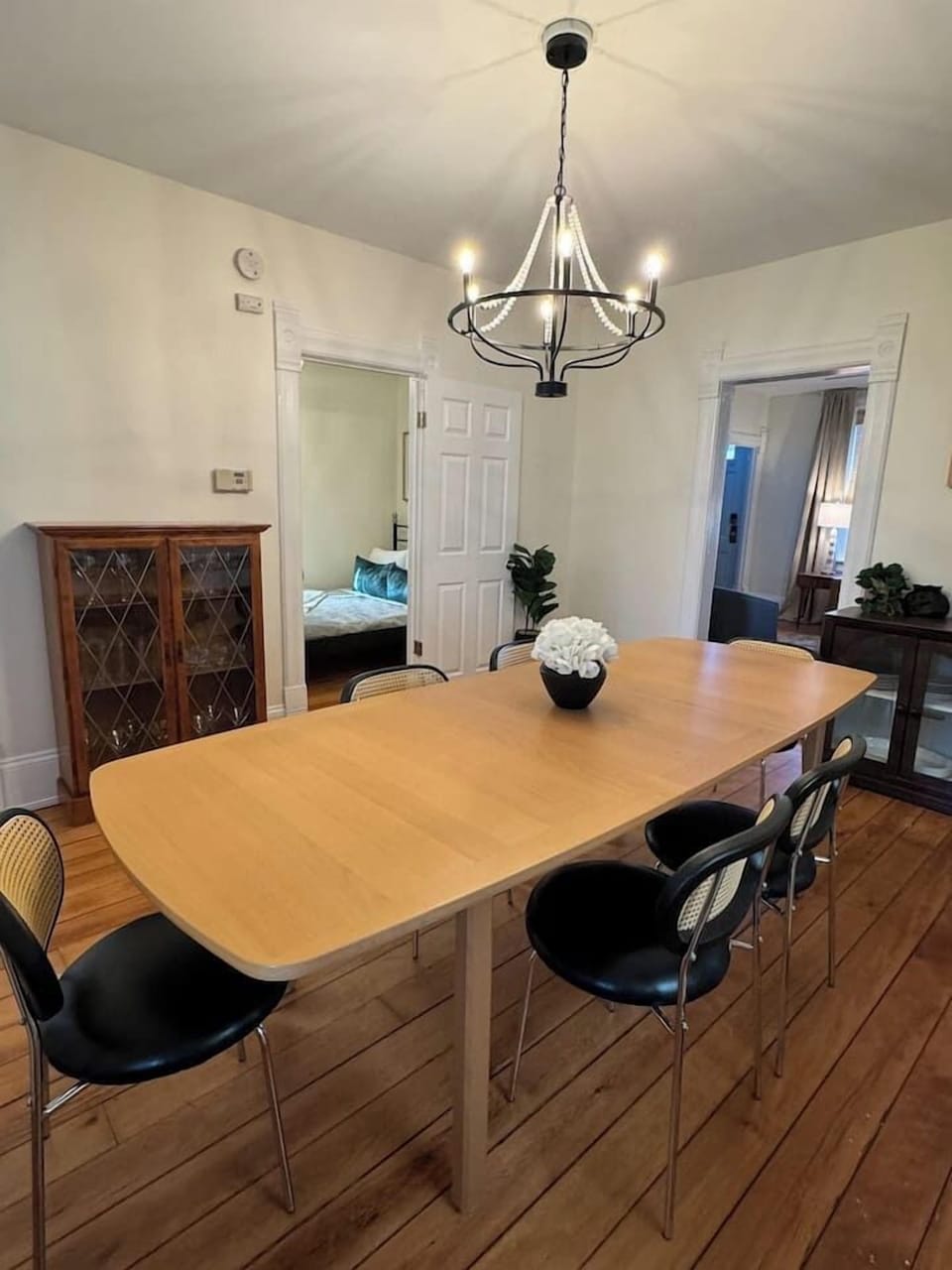 Spacious dining area with a large wooden table, surrounded by mixed seating.