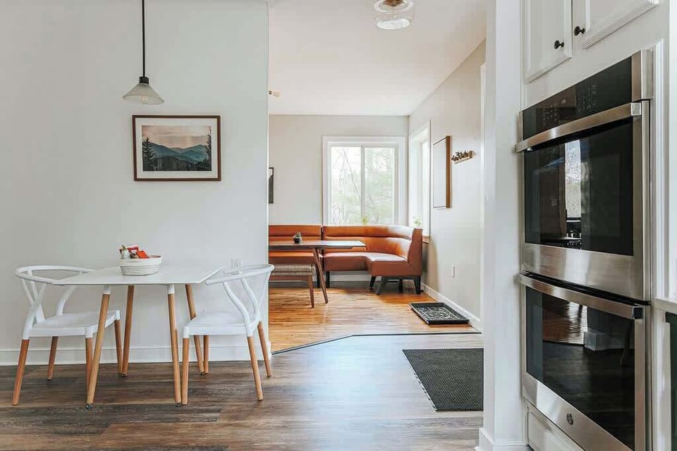 Dining table near the entry with hardwood floors throughout.