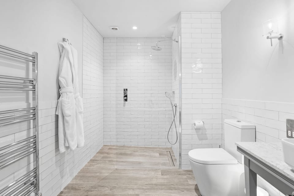 Bathroom fitted with roll top bath, a large shower cubicle, hand basin, mirror, heated towel rail and WC - Cottage Suite 5, Kentisbury Grange