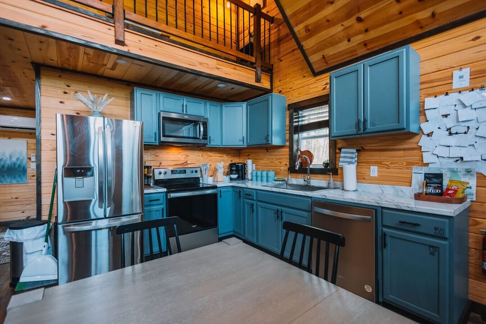 The kitchen features stainless steel appliances and comes fully stocked for your stay