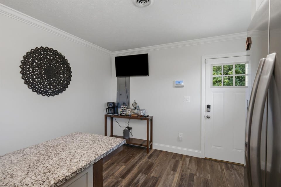 Bright entry with granite counter, beverage station, and wall-mounted TV