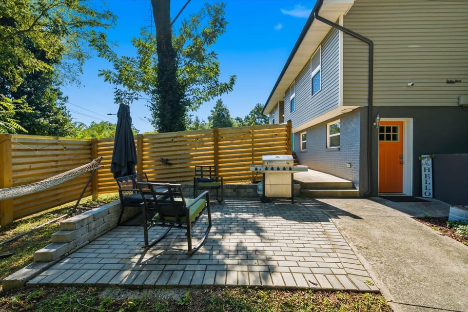 Private partically fenced patio with grill, hammock, large umbrella, and cozy outdoor seating