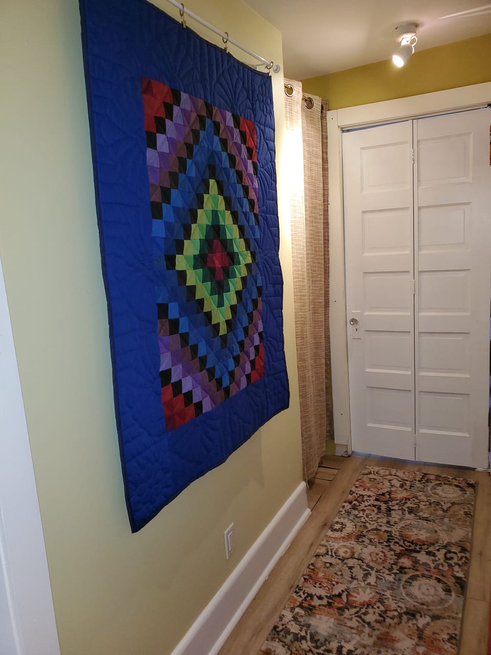 Hallway from center area to back bedroom, bath on left, W/D Amish quilt 