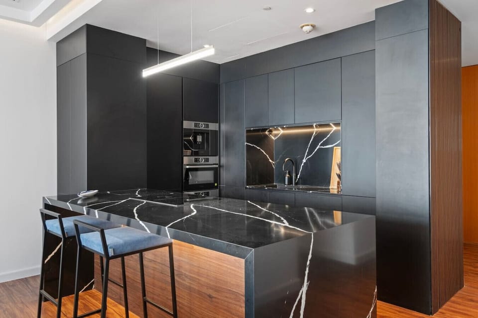 Gourmet Kitchen: Sleek black marble and chic bar stools make cooking a stylish affair!