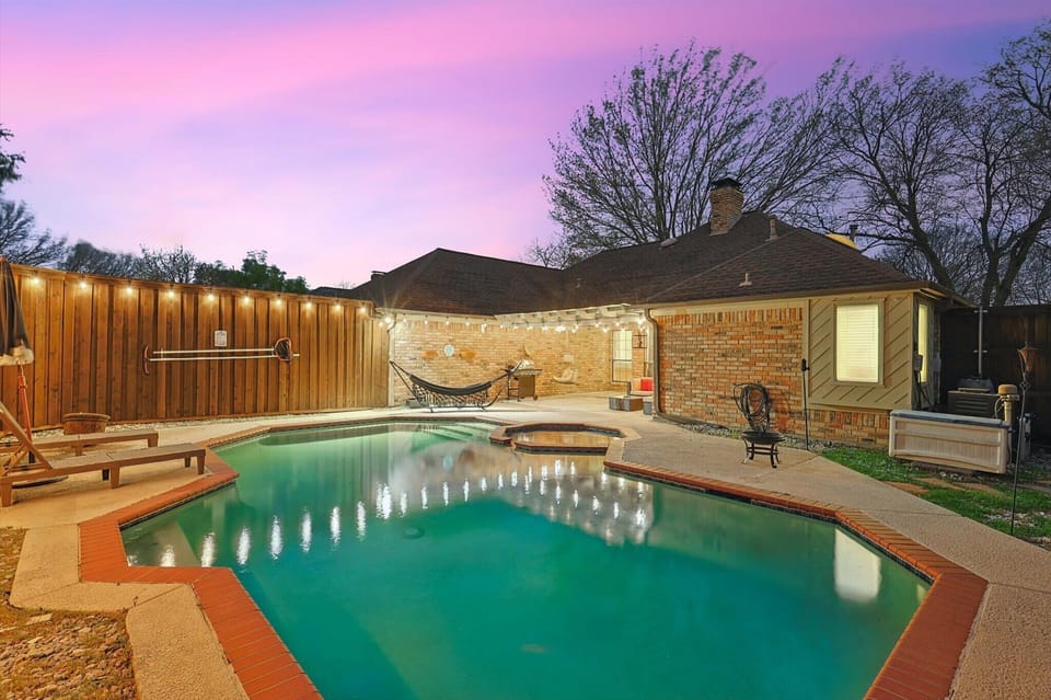 Unwind in this private paradise, featuring a sparkling pool, kiddie pool, and cozy hammock under the glow of string lights.