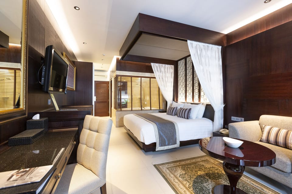 Santrian Deluxe Room | Minibar, in-room safe, desk, laptop workspace