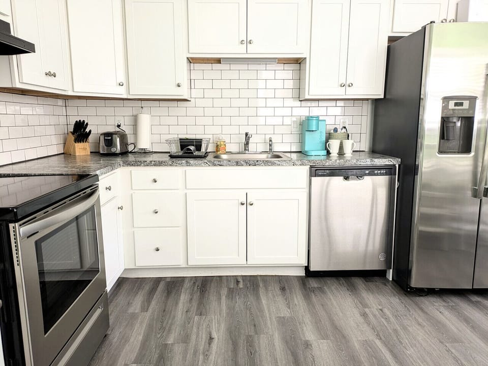 The kitchen is equipped with an electric stove, microwave, dishwasher, toaster, and fridge.