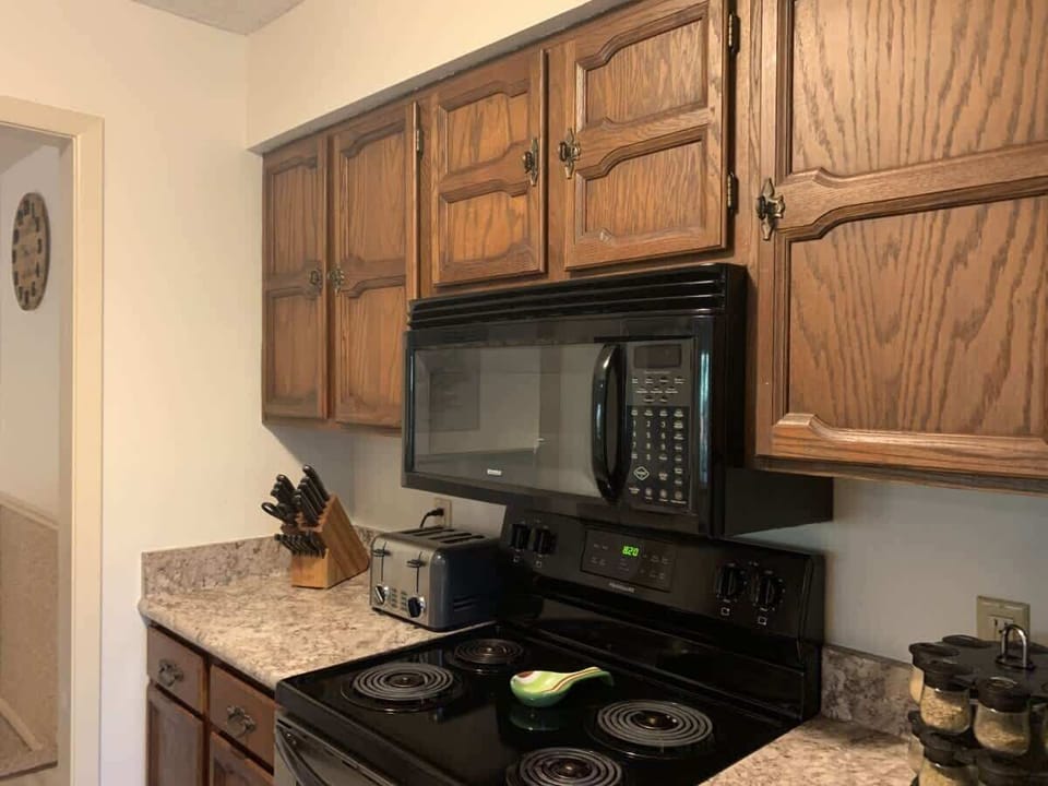 Classic kitchen setup with modern black appliances and plenty of counter space — fully stocked for your cooking needs.