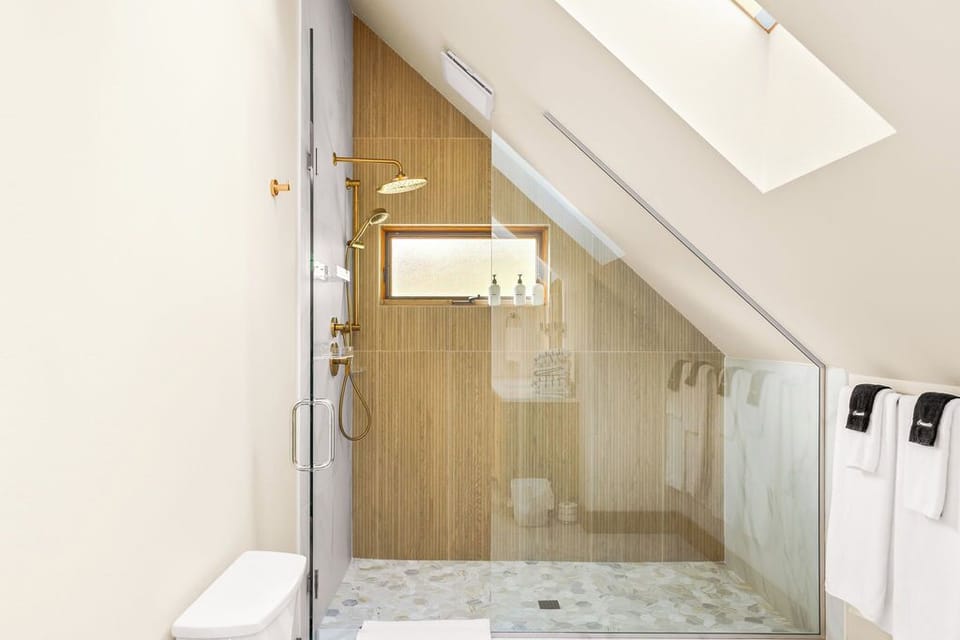 Elegant brass fixtures and a glass-enclosed walk-in shower for a luxe start to your day.