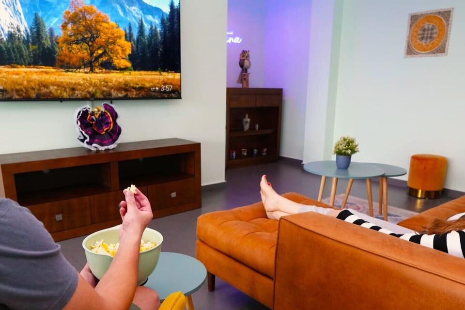 Kick back and relax in our stylish living room! Enjoy a movie night on the big screen with popcorn in hand. This cozy and colorful space is perfect for unwinding after a day of exploring Mexico City.
