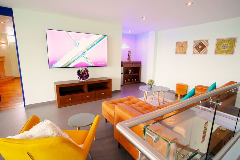 Discover your vibrant Mexico City retreat! This stylish living room features modern decor, a large smart TV for movie nights, and comfortable seating. Relax in a cozy, colorful space designed for comfort and fun.
