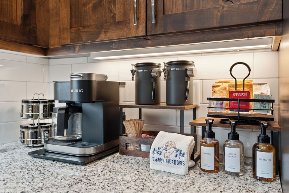 A coffee, tea, and cocoa bar is set up with a variety of options, including flavored syrups and multiple ways to brew. It’s a simple way to ease into the morning or relax together at the end of the day.