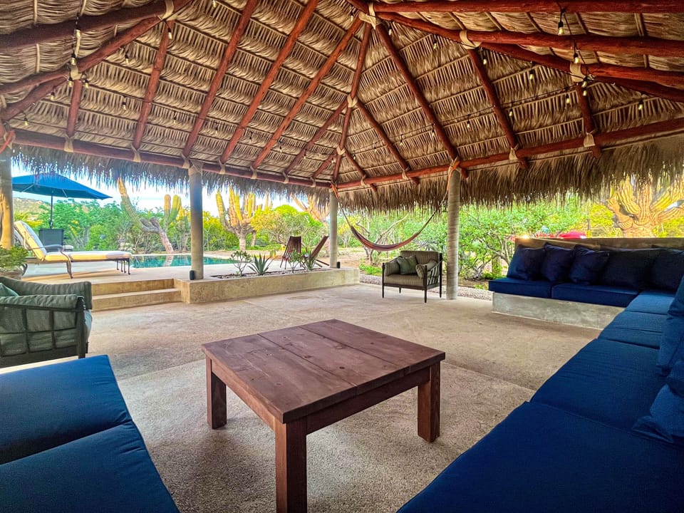 Plentiful seating with pool and garden views from under the palapa