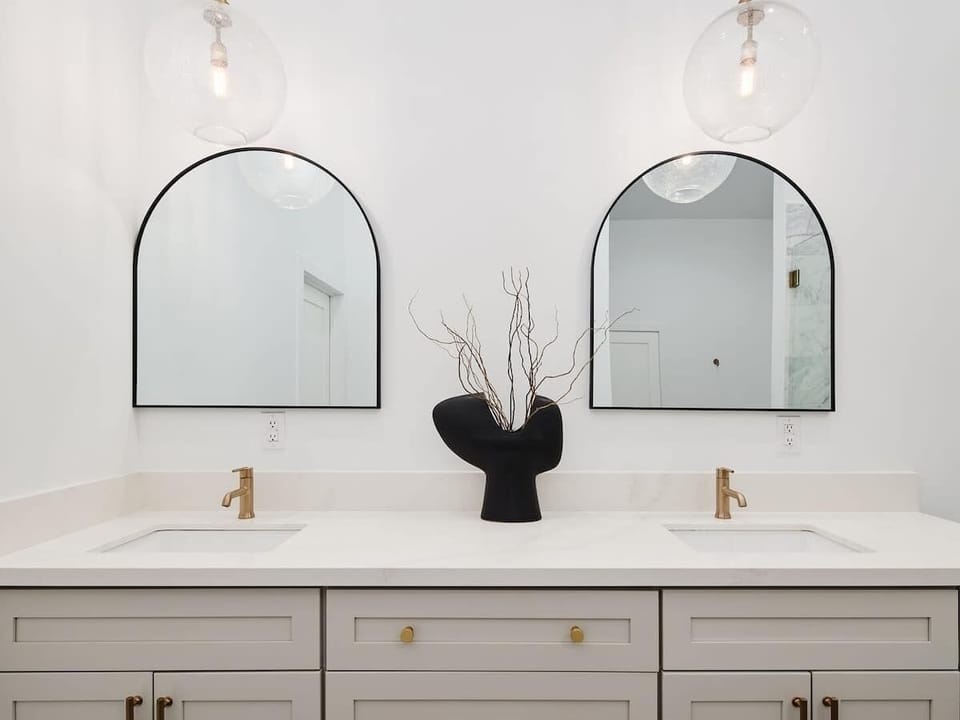 Primary Bathroom featuring a modern dual vanity with a luxurious stand-in shower, soaking tub, and walk-in closet.