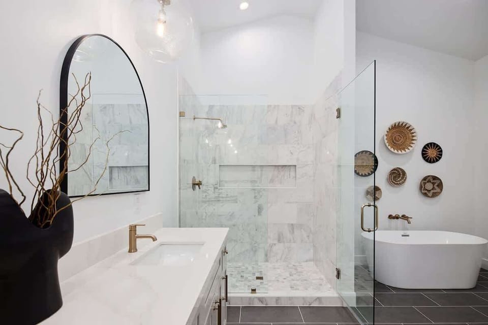 Primary Bathroom featuring a modern dual vanity with a luxurious stand-in shower, soaking tub, and walk-in closet.