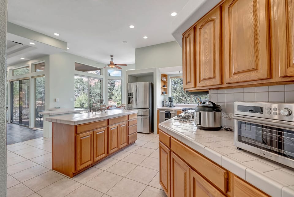 Fully equipped kitchen boasts high-end appliances, a 5-burner gas stove, and island seating for two