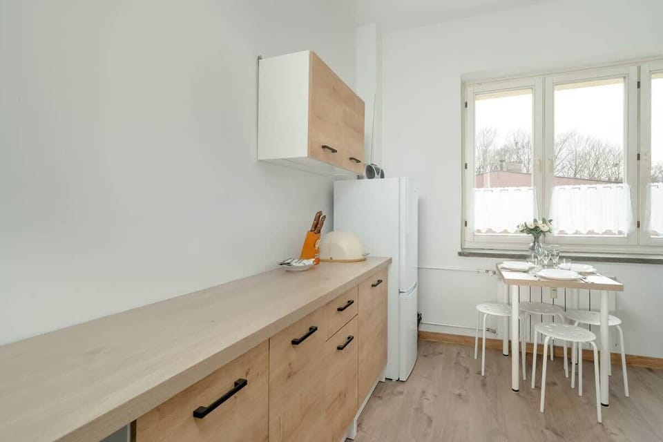 A kitchen view with wooden cabinets, a gas stove, and a window providing natural light, creating a well-lit and functional cooking area.

