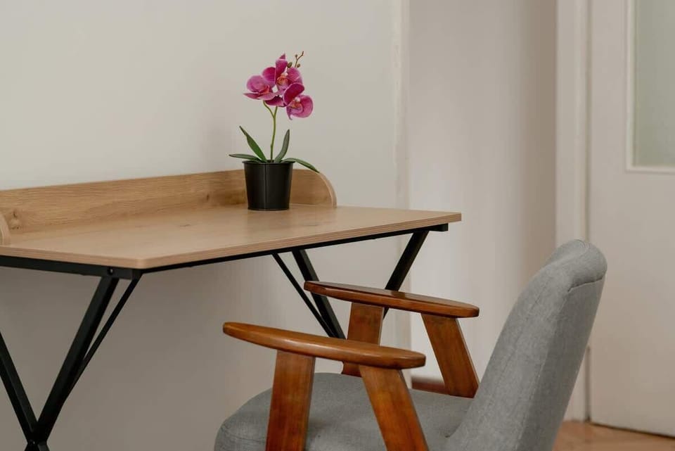 A minimalist dining area with a wooden sideboard, a small table, and chairs, bringing a clean and simple aesthetic to the home.


