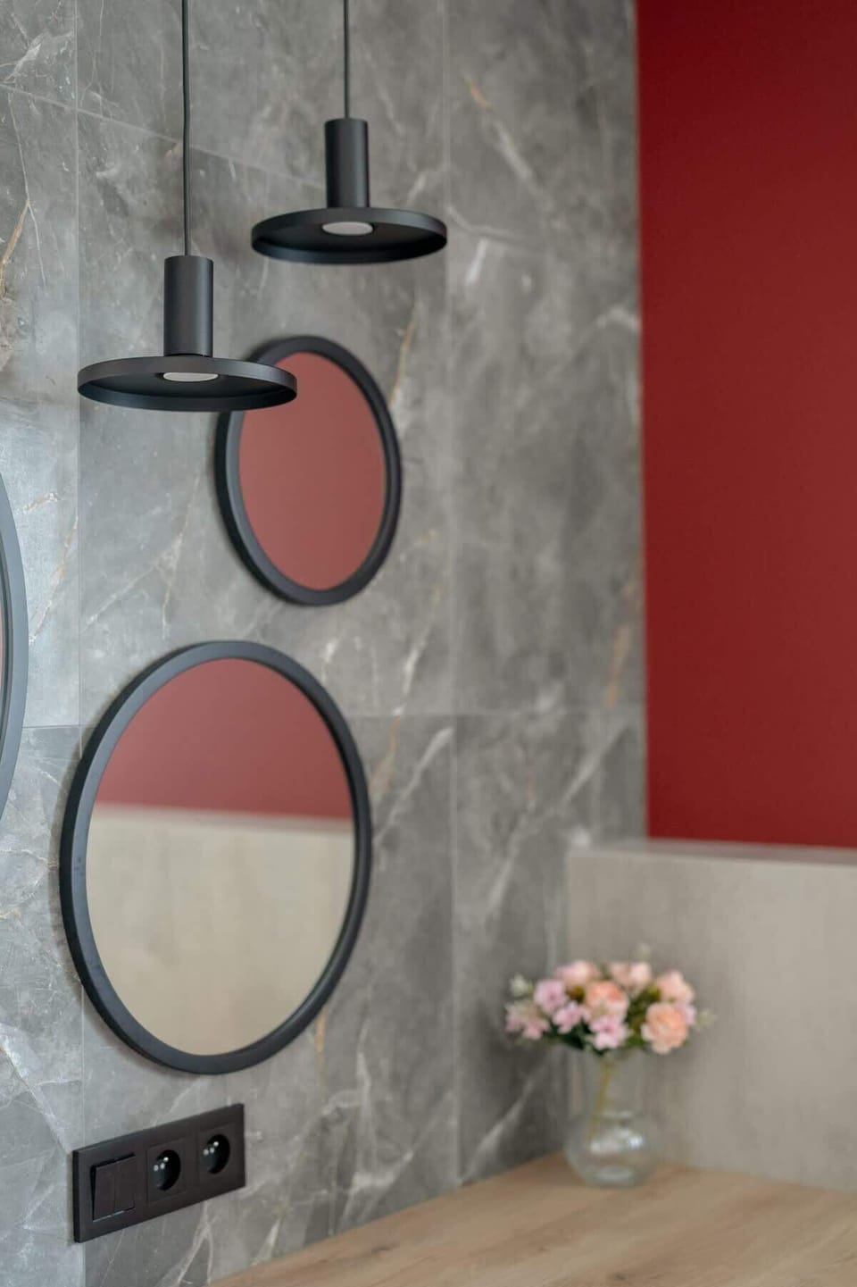  decorative red and black mirror on the bathroom wall with a modern aesthetic.