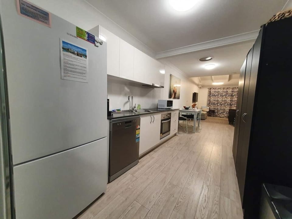 Fully equipped kitchen with fridge dishwasher induction stove top oven and microwave