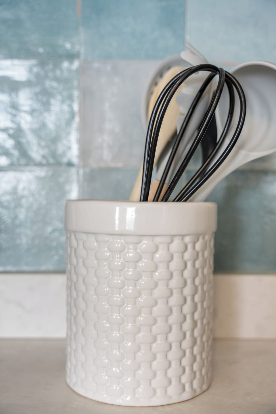 Styled kitchen details with elegant utensils and a fresh tile backsplash