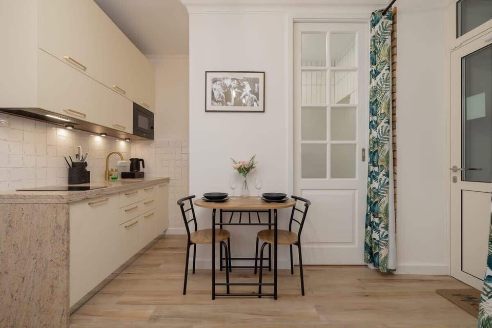 The bright kitchen with a wooden countertop and comfortable table creates a space perfect for both cooking and shared meals.